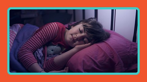 A young girl asleep in a bed.