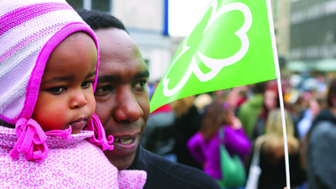 A man and baby at a Saint Patrick's Day parade in Northern Ireland - a celebration of Irish culture.