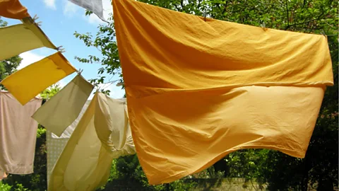 Yellow and orange sheets on washing line (Credit: Getty Images)