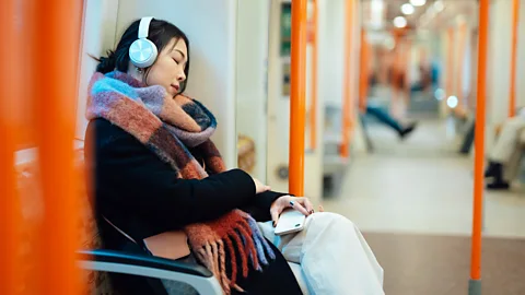 A woman sleeping on a train (Credit: Getty Images)