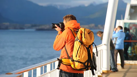 Passenger taking photos from deck (Credit: Jan Lillehamre/ Hurtigruten)