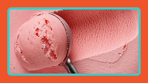 A pink coloured ice cream curled into a ball.