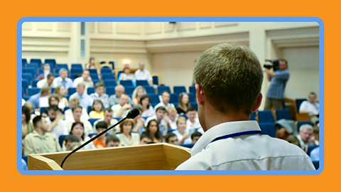 A man presenting at a conference.