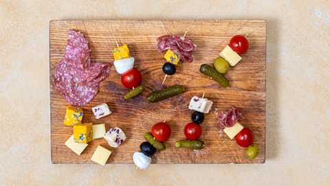 Charcuterie ingredients being placed onto cocktail sticks
