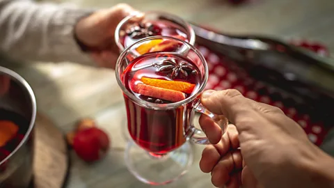 People holding glasses of vin chaud (Credit: Getty Images)