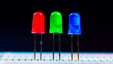 Red, green and blue light emitting diodes (LED) on a breadboard, dark background