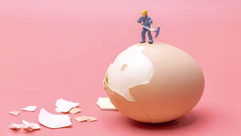 A toy figurine holding a pickaxe, posed with an egg with a broken shell (Credit: Getty Images)