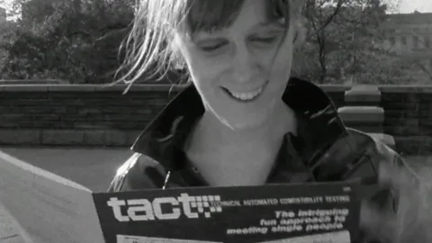 Woman looks down at Tact booklet (Credit: BBC)