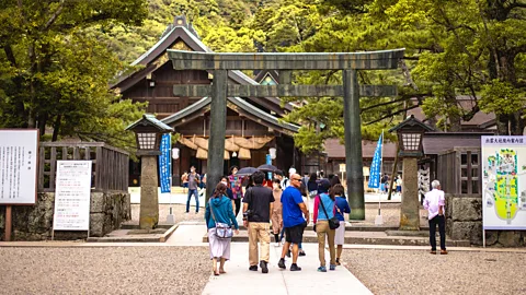 People walking under the bronze arch at Izumo Taisha Shrine (Credit: Getty Images)