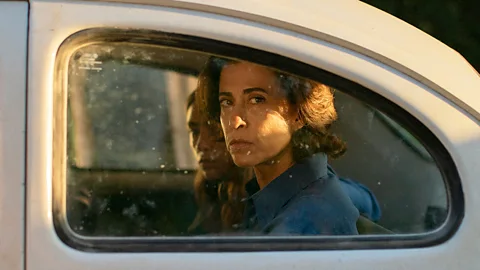 A still of Fernanda Torres sat in a car looking out of the window in I'm Still Here (Credit: Sony Pictures Classics)