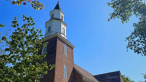 A view of a brick-sided church with a white steeple from the ground (Credit: Barbara Noe Kennedy)