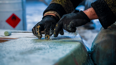 Boat maker putting glass fibres into polyester resin