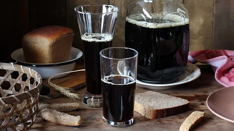 Glasses of kvass on a table with brown bread (Credit: Getty Images)