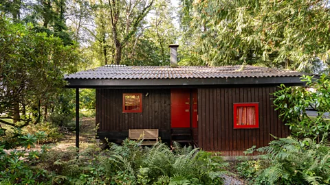 A simple wooden cabin in a forest setting