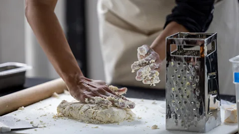 Hands kneading biscuit dough next to a grater (Credit: Karen Cox)
