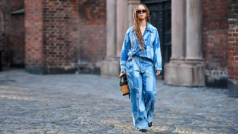 A woman in checkered jean top and bottoms (Credit: Getty Images)