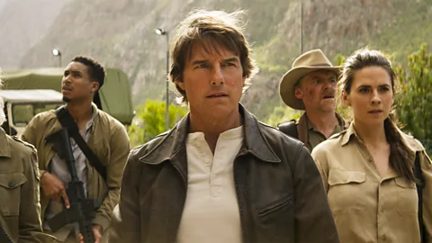 A still of Tom Cruise hanging from a plane with land beneath him in Mission: Impossible – The Final Reckoning (Credit: Courtesy of Cannes FIlm Festival)