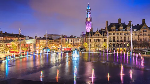 Bradford City Hall in Centenary Square, Bradford, West Yorkshire, England, illuminated at night with the fountains in the foreground (Credit: Getty Images)