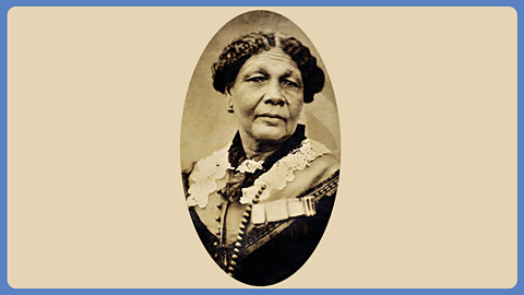 A sepia photograph of an elderly woman wearing 19th Century clothes