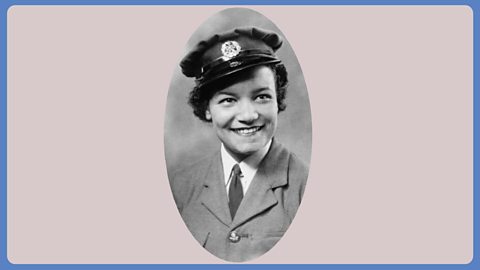 A black and white photograph of a young woman smiling, dressed in army uniform.
