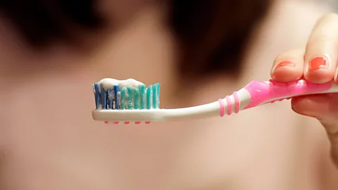 Close up picture of a fraying toothbrush head with a blue background (Credit: Getty Images)