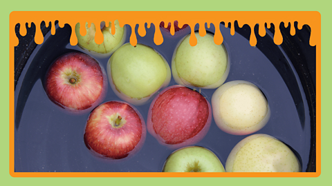 Green and red apples in a large bowl of water