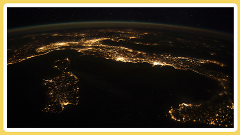 A night time image of the Earth showing the lights of Italy