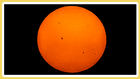 The Sun as a bright orange sphere against a black background