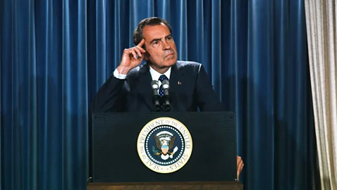 President Nixon stood at a podium with his finger resting on his temple (Credit: Getty Images)