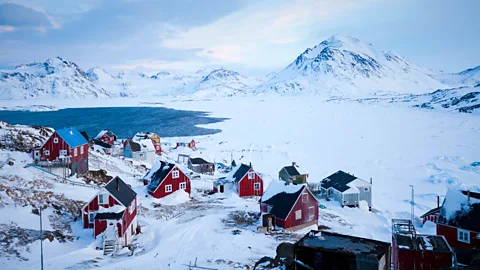 A collection of wooden houses from the village of Kulusuk amongst the snow in Greenland (Credit: Nigel Baker and GEUS)