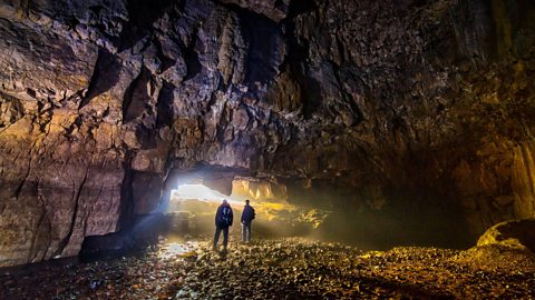 Two explorers in a large cave in the Yorkshire Dales