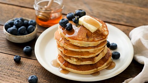 Fluffy, American style pancakes with butter, honey and blueberries