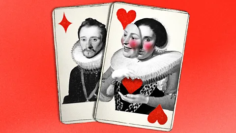 Against a bright red background sit two playing cards, one is a man on a diamond and a woman is on a heart. The woman has a mask in front of her face, as if she has two personalities (Credit: Serenity Strull/ BBC)