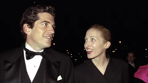 John F Kennedy Jr and Carolyn Bessette smiling at each other (Credit: Getty Images)