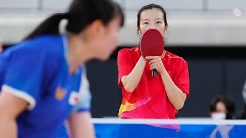 Chinese competitor Sun Boyao holds her table tennis bat in front of her face while playing against yamad Moemi of Japan at the Deaflympics in Tokyo (Credit: Alamy)