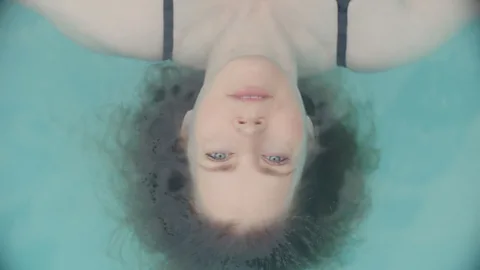 Amy Adams lying upside down in a swimming pool in At the Sea (Credit: ATS Production)