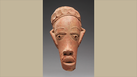 A carved stone figure depicting a person.