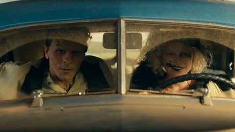 Christian Bale and Jessie Buckley sat in a car in The Bride! (Credit: Alamy)