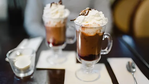 Two glass mugs of Lumumba cocktail with cocoa and whipped cream on a café table (Credit: Getty Images)