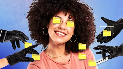 A woman smiling with two pairs of black-gloved hands placing computer folders on he eyes and body (Credit: Serenity Strull/ BBC)