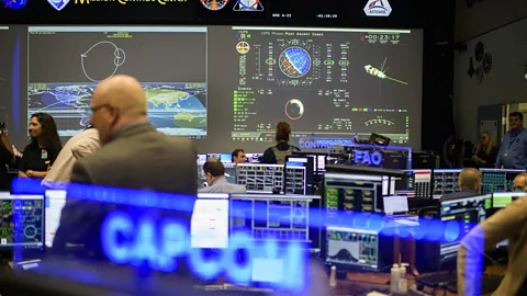 Artemis Mission Control, a modern room with many desks and screens facing one large central screen covered in information (Credit: Getty Images)
