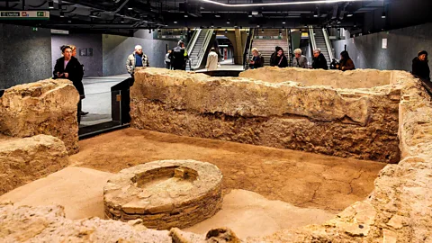 Commuters admire the remains of a Roman bath in the Colosseo-Fori Imperiali Metro C archaeo-station in Rome, with the station steps visible in the background( Credit: Alamy)