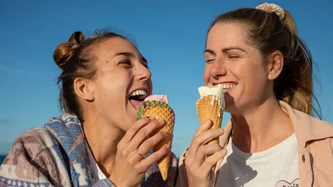 Two women each enjoying an ice cream and smiling (Credit: Getty Images)