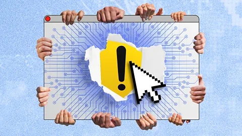 Several hands hold computer windows with "X" and exclamation point warning signs over a desktop screen that says "AI" (Credit: Serenity Strull/ BBC/ Getty Images)