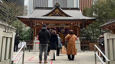 A group of people walk outside a shrine in Tokyo, Japan (Credit: Erika Ebsworth-Goold)