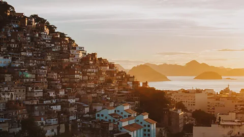 A view of a favela in Rio at sunrise with the sea and islands in the background (Credit: Alamy)