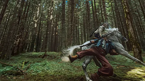 A still of two men riding a horse through the woods, with one of the men mid-falling off, in Hope (Credit: Neon)