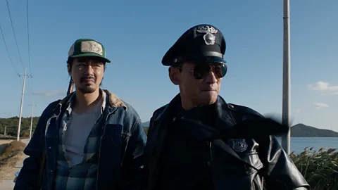 A still of two men riding a horse through the woods, with one of the men mid-falling off, in Hope (Credit: Neon)