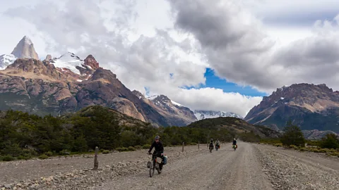 People cycling in Patagonia with mountains behind them (Credit: Douwe den Held)