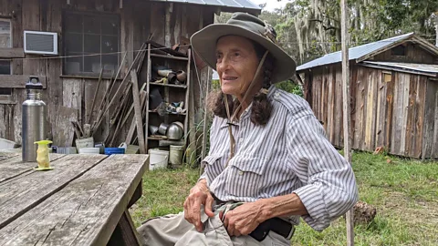 Carol Ruckdeschel wears a hat and sits at a bench Credit: Alexandra Marvar)